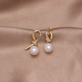 Pendientes de oro con nudos y perla de agua dulce